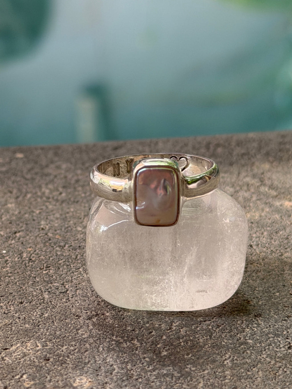 Silver ring with a naturall pearl on a textured surface