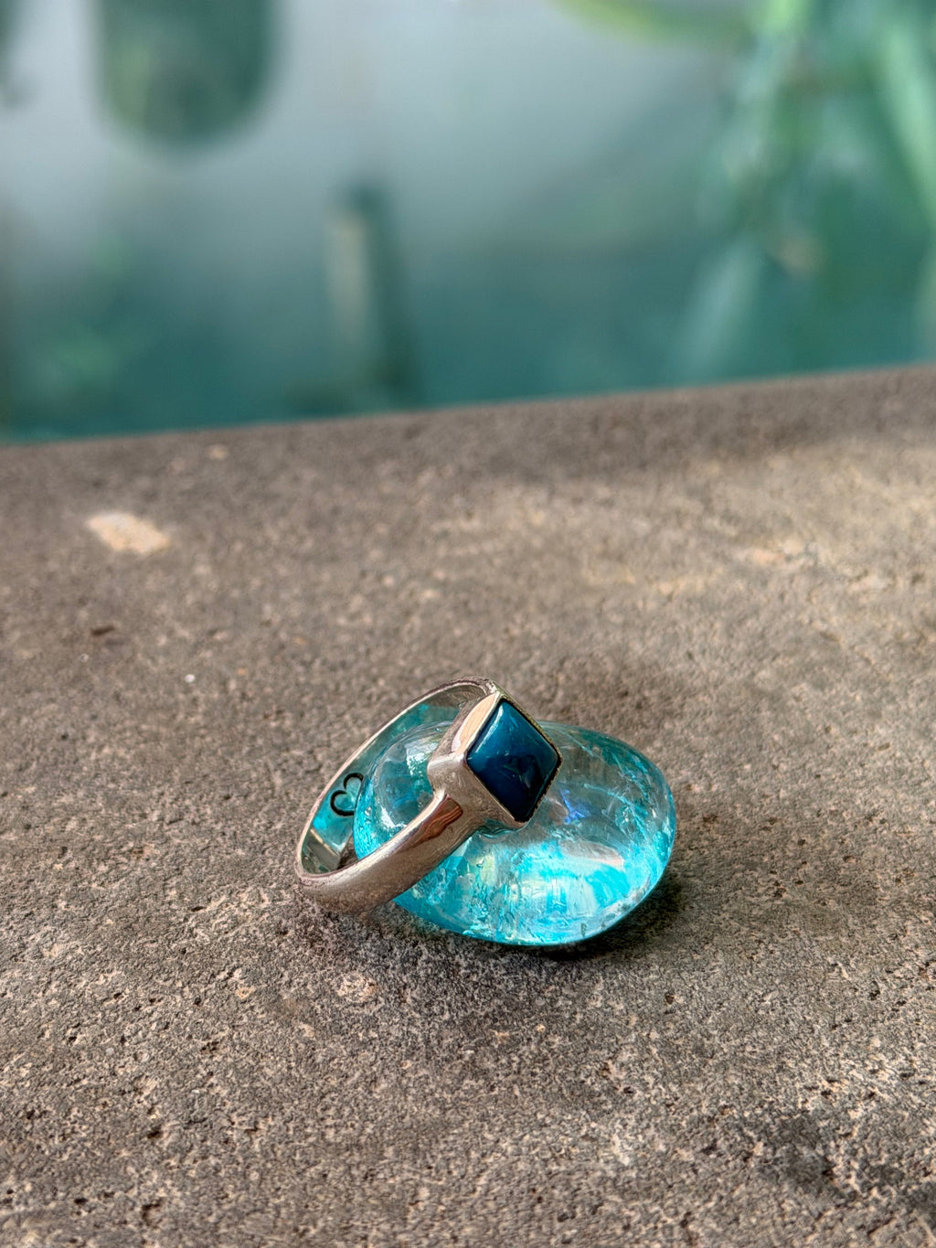 Ring with blue gemstone on a concrete surface